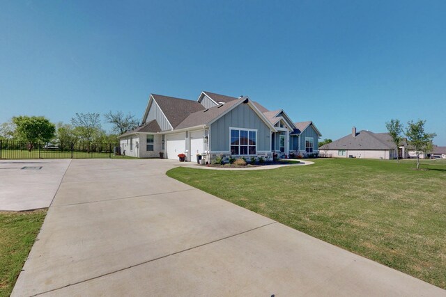 view of front facade featuring fence, a front lawn, a garage, board and batten siding, and concrete driveway