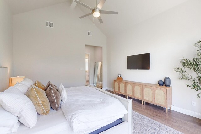 bedroom featuring visible vents, beam ceiling, wood finished floors, high vaulted ceiling, and baseboards