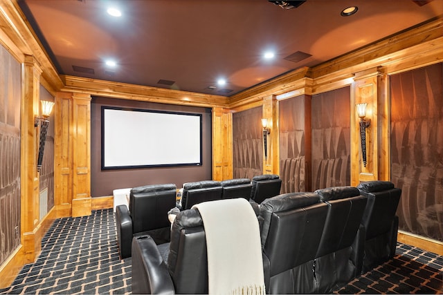 home theater room featuring ornamental molding, recessed lighting, wood walls, and dark colored carpet