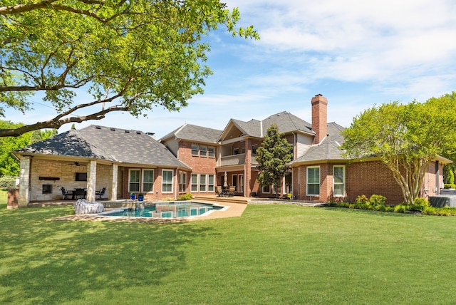 back of house with a lawn, ceiling fan, a patio, and brick siding