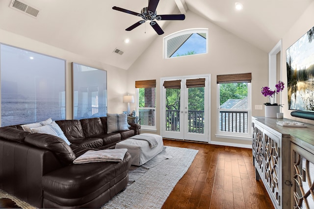 living room with dark wood-style floors, a ceiling fan, visible vents, and high vaulted ceiling