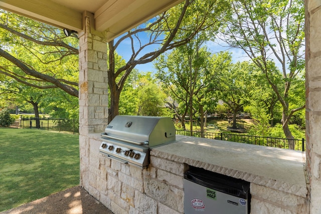 view of patio featuring area for grilling, a grill, and fence