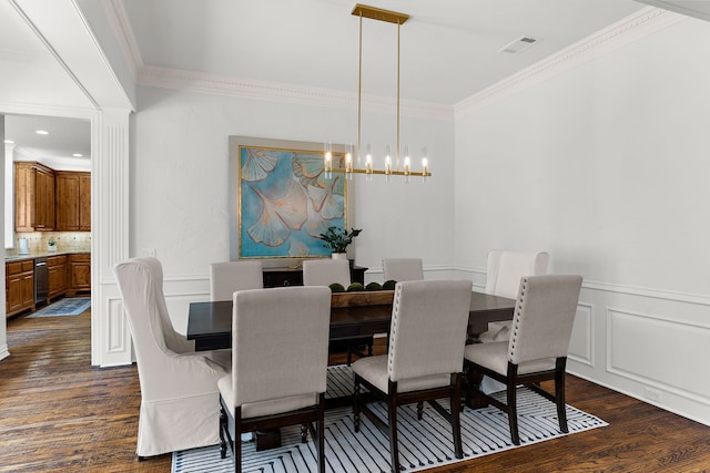 dining area with visible vents, ornamental molding, a wainscoted wall, and dark wood-type flooring