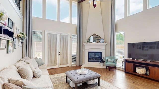 139 Townlake Dr, Prosper, TX 75078 - living area featuring a high ceiling, a large fireplace, wood finished floors, and a ceiling fan