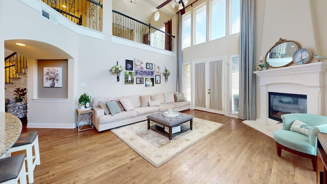 139 Townlake Dr, Prosper, TX 75078 - living area featuring a high ceiling, wood finished floors, plenty of natural light, baseboards, and a glass covered fireplace