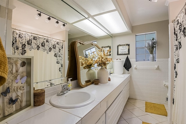 bathroom with tile patterned floors, tile walls, crown molding, and a sink