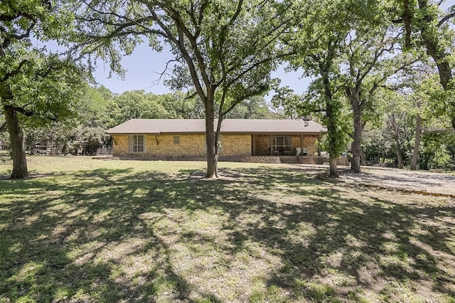 view of front of home with brick siding, a porch, and a front yard
