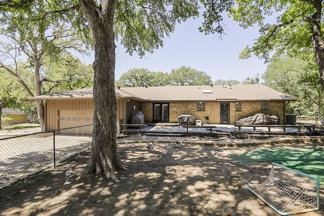 exterior space with board and batten siding, brick siding, fence, driveway, and an attached garage