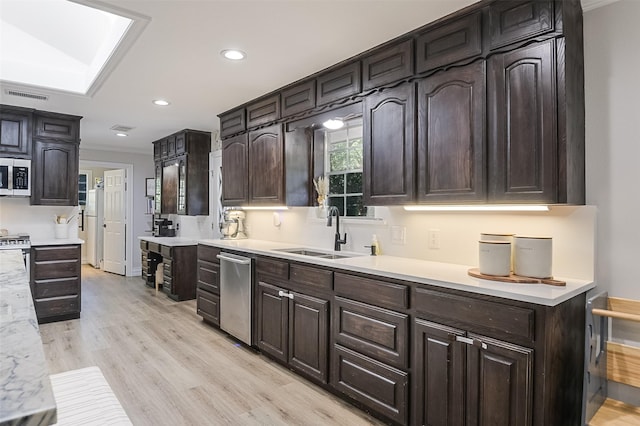 kitchen featuring light wood finished floors, a sink, visible vents, light countertops, and appliances with stainless steel finishes