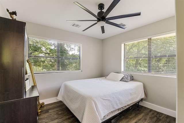 bedroom with a ceiling fan, visible vents, wood finished floors, and baseboards