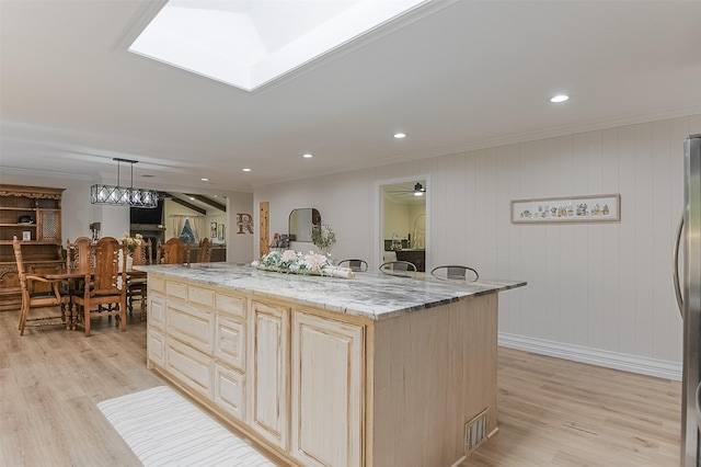 kitchen with light brown cabinets, light wood-type flooring, and ornamental molding