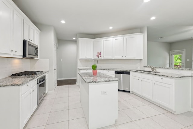6500 Roaring Crk, Denton, TX 76226 - kitchen featuring stainless steel appliances, a sink, a peninsula, decorative backsplash, and recessed lighting