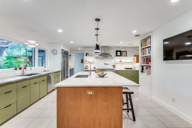 416 Crestwood Dr, Fort Worth, TX 76107 - kitchen featuring a sink, appliances with stainless steel finishes, wall chimney range hood, and green cabinets