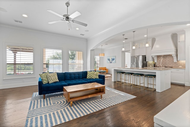2200 Whitman Ln, Carrollton, TX 75010 - living area with dark wood-style flooring, ceiling fan, recessed lighting, ornamental molding, and arched walkways