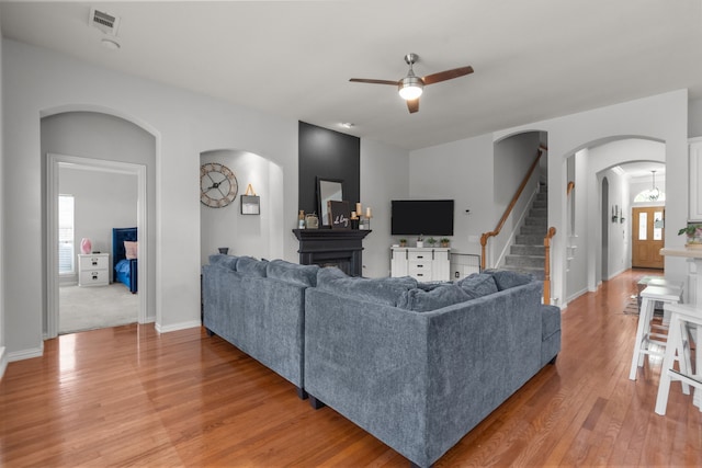 2209 Graystone Ct, Keller, TX 76248 - living area featuring arched walkways, ceiling fan, light wood-type flooring, and plenty of natural light