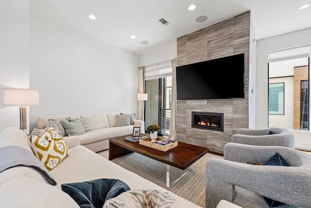 living area featuring recessed lighting, visible vents, and a fireplace