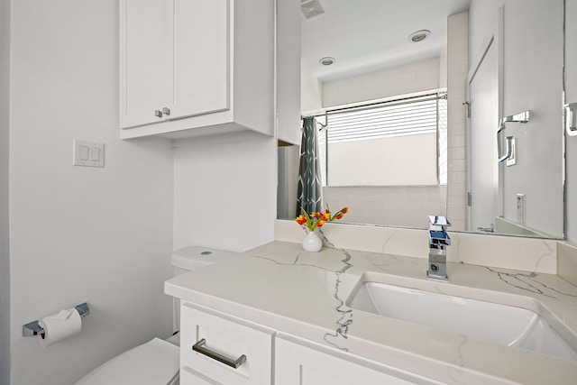 bathroom with visible vents, toilet, and vanity