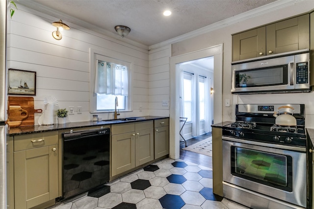 kitchen featuring crown molding, a textured ceiling, a sink, and appliances with stainless steel finishes