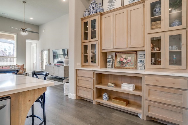 kitchen featuring light brown cabinets, dark wood-style floors, visible vents, a ceiling fan, and open floor plan