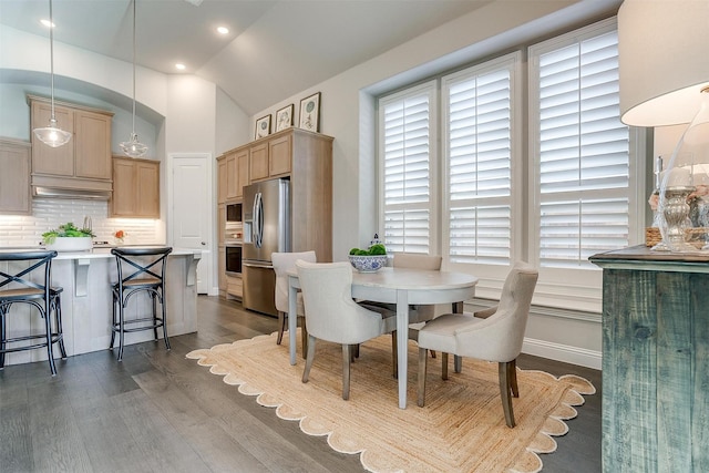 dining space with lofted ceiling and dark wood-style flooring