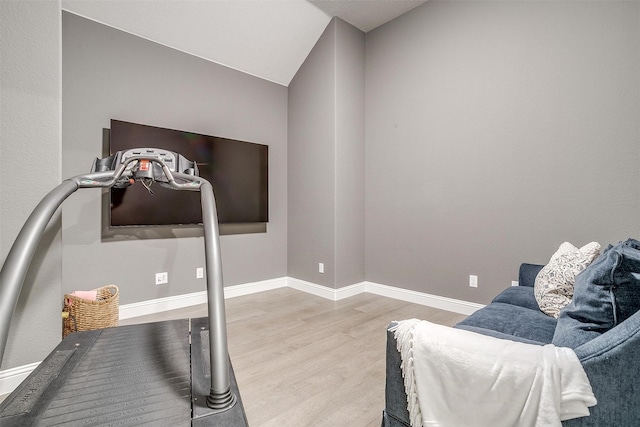 exercise room with baseboards and wood finished floors