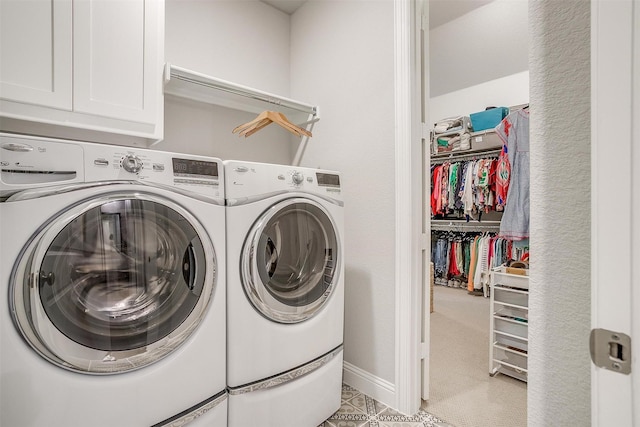 laundry area with baseboards, washer and dryer, and cabinet space
