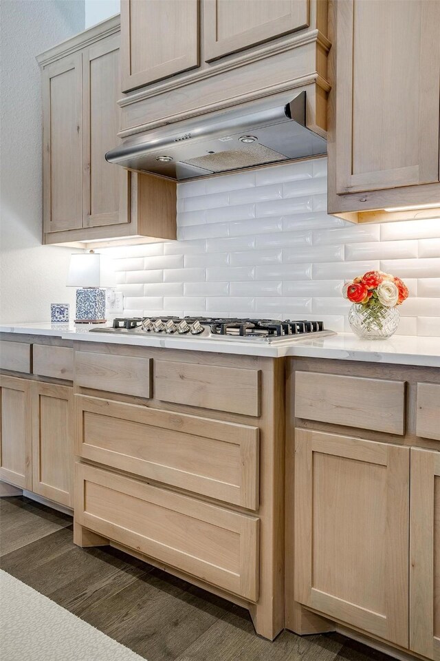 kitchen with light brown cabinetry, custom exhaust hood, tasteful backsplash, and light countertops