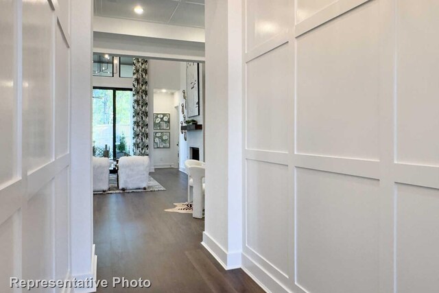 hallway featuring dark wood finished floors and baseboards