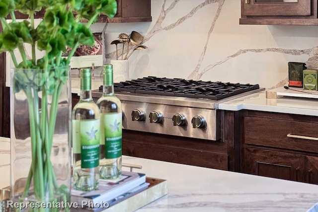 room details with stainless steel gas cooktop, dark brown cabinetry, and light countertops