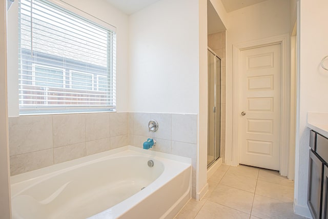 bathroom with a bath, tile patterned flooring, a shower stall, and vanity