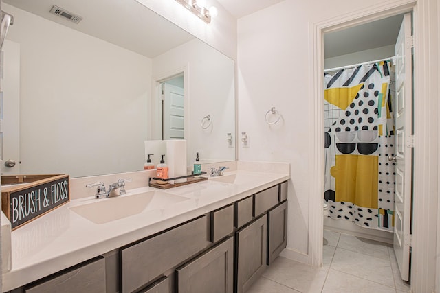 bathroom with double vanity, visible vents, tile patterned floors, and a sink