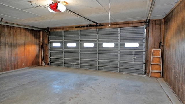 garage featuring wood walls and a garage door opener