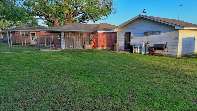 back of property featuring a gate, fence, and a yard