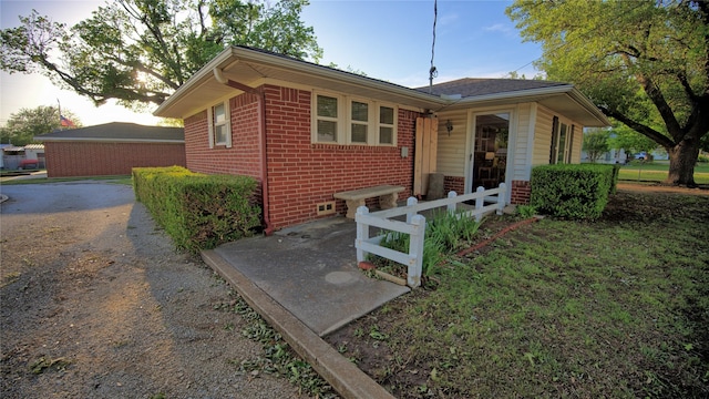 view of front facade featuring brick siding and fence