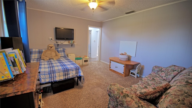 carpeted bedroom with visible vents, ornamental molding, a ceiling fan, and a textured ceiling
