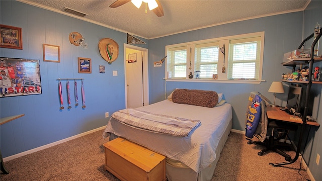 carpeted bedroom featuring ornamental molding, ceiling fan, baseboards, visible vents, and a textured ceiling