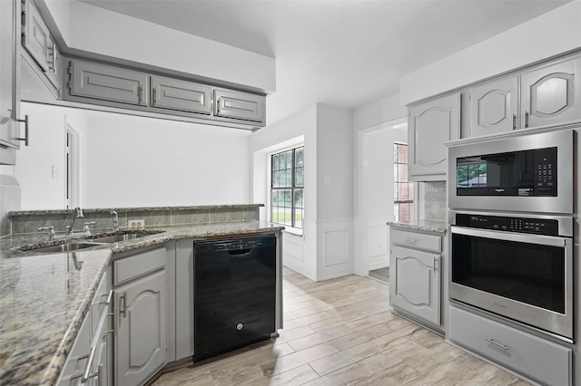 829 Hunters Creek Dr, Desoto, TX 75115 - kitchen featuring built in microwave, a sink, gray cabinetry, dishwasher, and stainless steel oven