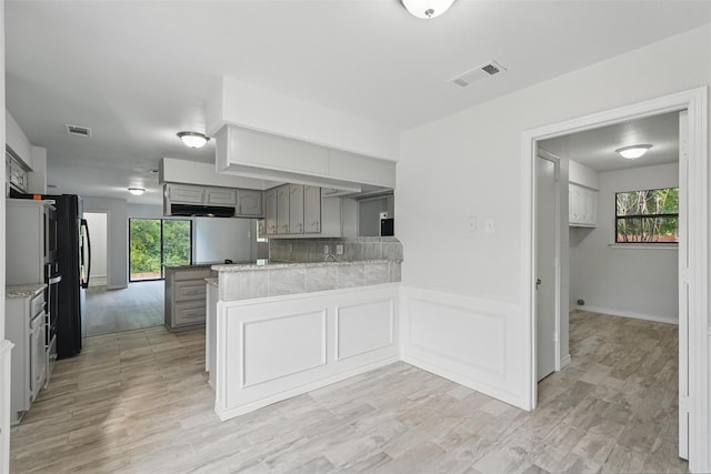 829 Hunters Creek Dr, Desoto, TX 75115 - kitchen featuring light wood-style flooring, gray cabinets, a peninsula, and visible vents