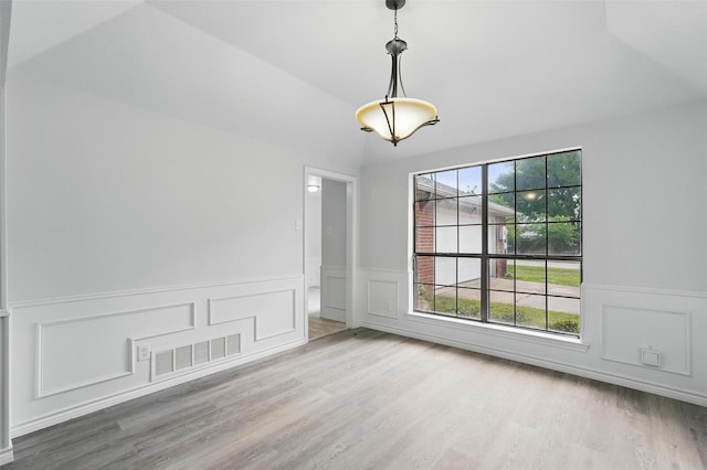 829 Hunters Creek Dr, Desoto, TX 75115 - unfurnished dining area featuring lofted ceiling, visible vents, wainscoting, and wood finished floors