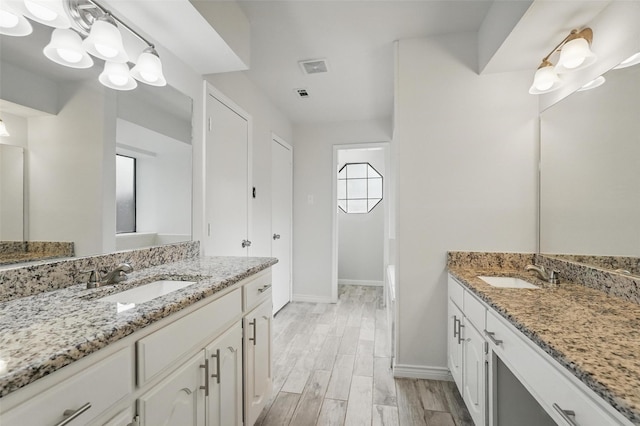 829 Hunters Creek Dr, Desoto, TX 75115 - full bathroom featuring two vanities, wood finished floors, baseboards, and a sink