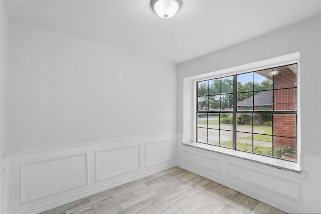 829 Hunters Creek Dr, Desoto, TX 75115 - spare room with wainscoting, light wood-style flooring, and a decorative wall
