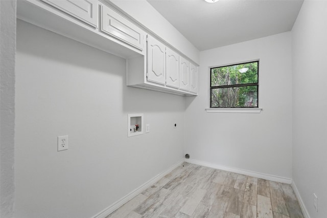 829 Hunters Creek Dr, Desoto, TX 75115 - laundry room with cabinet space, washer hookup, electric dryer hookup, light wood-style flooring, and baseboards
