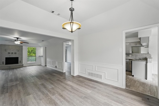 829 Hunters Creek Dr, Desoto, TX 75115 - unfurnished living room with visible vents, ceiling fan, wood finished floors, and a fireplace
