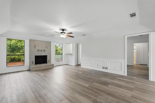 829 Hunters Creek Dr, Desoto, TX 75115 - unfurnished living room featuring a brick fireplace, a ceiling fan, visible vents, and wood finished floors