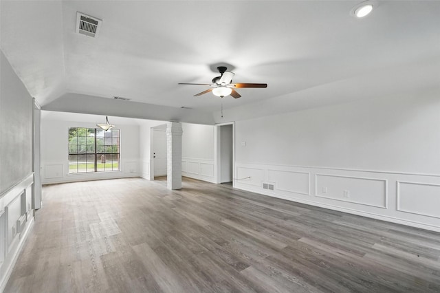 829 Hunters Creek Dr, Desoto, TX 75115 - unfurnished living room featuring lofted ceiling, visible vents, a decorative wall, wood finished floors, and a ceiling fan