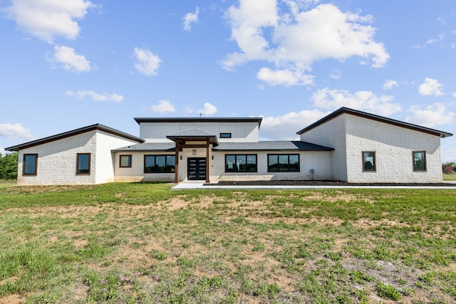 view of front facade featuring brick siding and a front lawn