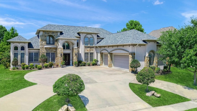 french provincial home featuring stucco siding, stone siding, a front lawn, concrete driveway, and an attached garage