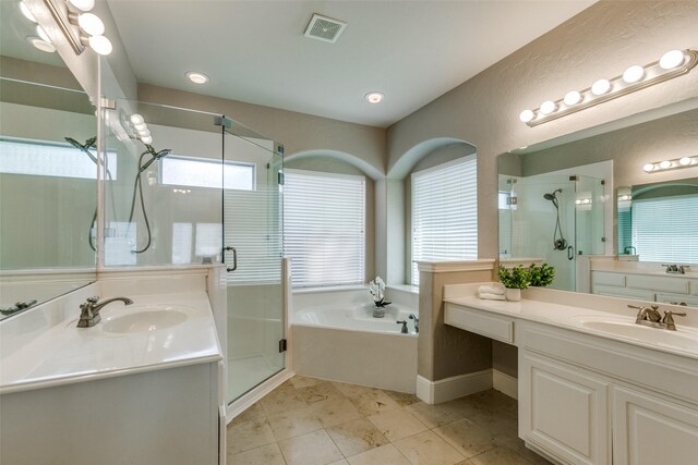 bathroom featuring visible vents, a stall shower, and a sink