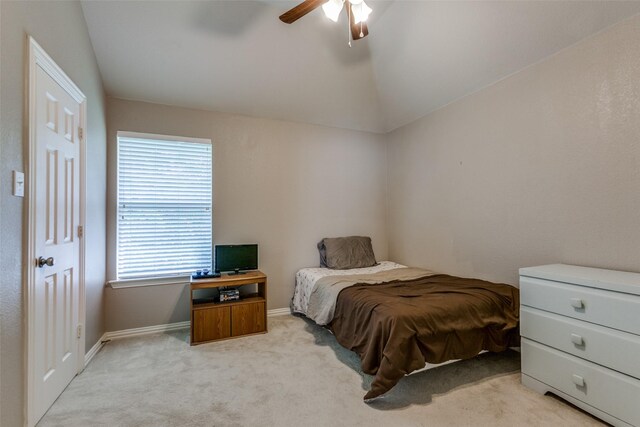 bedroom with a ceiling fan, vaulted ceiling, light colored carpet, and baseboards