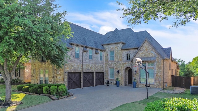 3040 N Camino Lagos, Grand Prairie, TX 75054 - french country home with cooling unit, driveway, stone siding, an attached garage, and fence